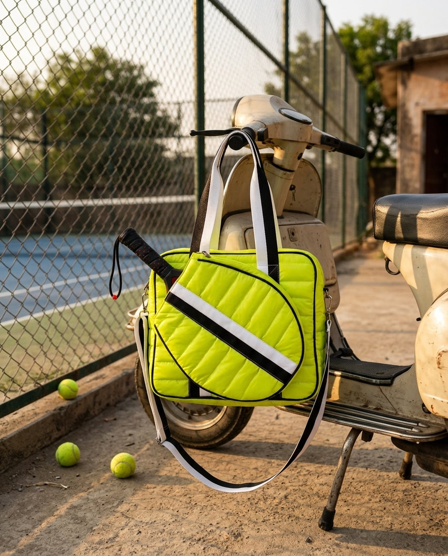 Court Club Puffer Tote Padel hanging from a Vespa scooter beside a padel court
