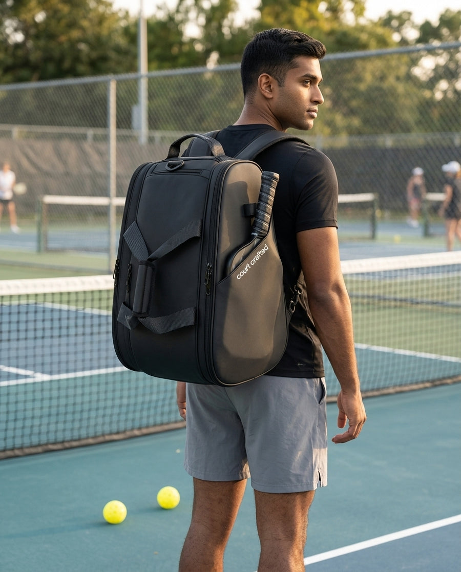 Man wearing the Court Club Backpack, paddle sleeve with court crafted wordmark facing the camera